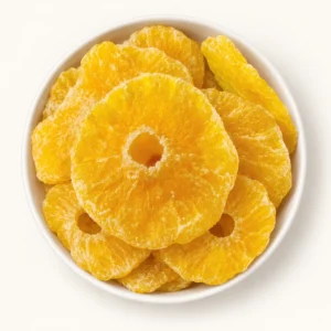 Golden dried pineapple rings arranged in an ivory bowl